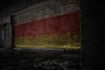painted flag of south ossetia on the dirty old wall in an abandoned ruined house.