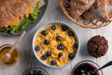 Homemade breakfast. Delicious traditional food. Croissant, corn flakes, baguette, sandwich. White background. Kitchen