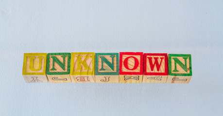 The term unknown visually displayed in colored toy blocks on a clear background image with copy space in landscape format