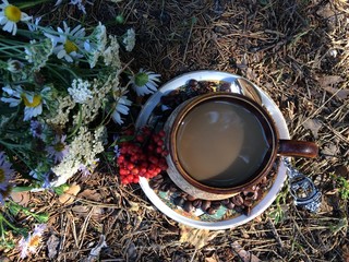 A cup of coffee is beautifully laid out in the grass