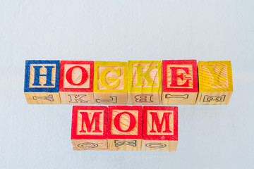 The term hockey mom visually displayed in colored toy blocks on a clear background image with copy space in landscape format