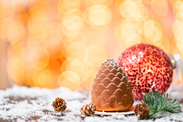 Dessert in the form of Christmas cone. Mini mousse pastry dessert covered with velour. Garland...