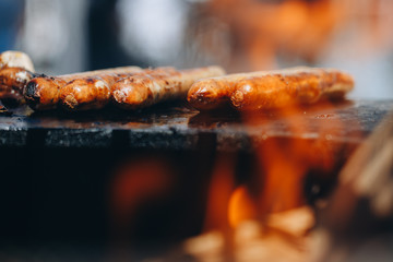 appetizing juicy chicken sausages on the grill close-up