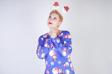 pretty blonde girl with short hair wearing christmas funny bright dress on white studio background alone