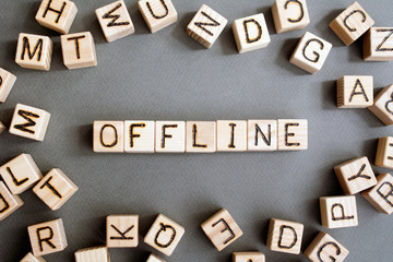 the word offline  wooden cubes with burnt letters, distracting people from social networks,  gray...