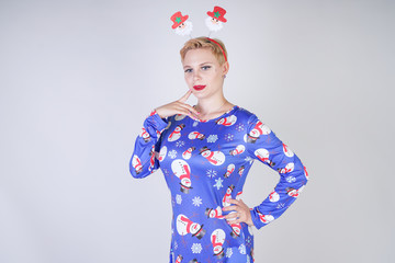 pretty blonde girl with short hair wearing christmas funny bright dress on white studio background alone