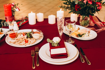 Round white table with elegant compositions from natural flowers. Banquet at the luxury wedding. Elegant design wedding table.