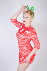 pretty blonde girl with short hair wearing christmas funny bright dress on white studio background alone