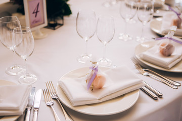 Round white table with elegant compositions from natural flowers. Banquet at the luxury wedding. Elegant design wedding table.