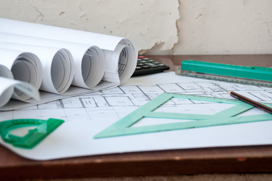 On The Table Are Folded Drawings Of The Apartment, Working Documentation, Compass, Protractor, Ruler, Pencil And Calculator, Preparation For Repair