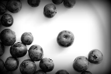 Fresh blueberry on a white plate close up. Top view black and white