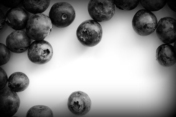 Fresh blueberry on a white plate close up. Top view black and white