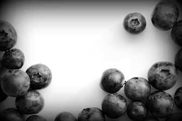 Fresh blueberry on a white plate close up. Top view black and white