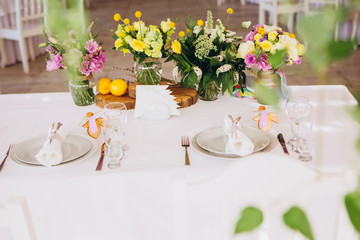 Round white table with elegant compositions from natural flowers. Banquet at the luxury wedding. Elegant design wedding table.