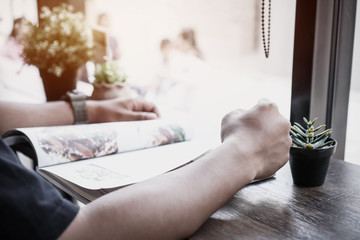 Adult education Learning Studying concept : Student Smart man sitting reading book on desk for learning or relax by self at coffee shop in university or college