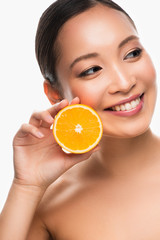 attractive cheerful asian girl holding orange, isolated on white