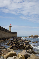 Fototapeta na wymiar View from Carneiro beach in Porto to pier and lighthouse Felgueiras.