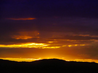 Landscape with sunset and silhouettes of trees. Beautiful view of bright colorful sky happened on evening decline in the summer evening.