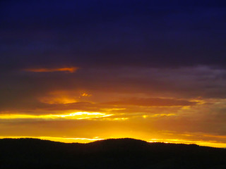 Landscape with sunset and silhouettes of trees. Beautiful view of bright colorful sky happened on evening decline in the summer evening.