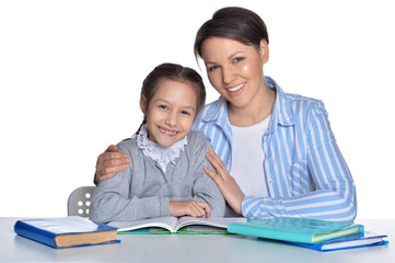 Mother with daughter doing homework on white background