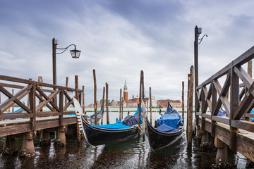 Gondolas parked in Venice, Italy. View of the Venetian Lagoon in the rainy weather