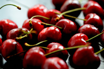 Ripe sweet cherry berries with water drops illuminated by a back light close up