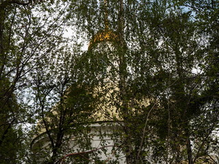 the church peeps through the trees in the park