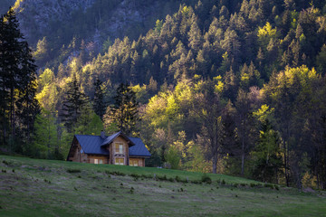 Alpine valley with summer house in sunset