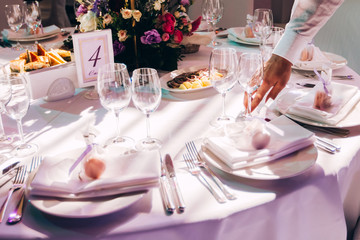 Round white table with elegant compositions from natural flowers. Banquet at the luxury wedding. Elegant design wedding table.