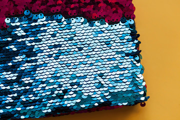 Beautiful iridescent sequins texture, fish scale fabric background, close up