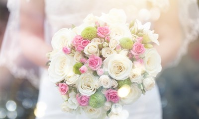 Bride with beautiful wedding bouquet on background