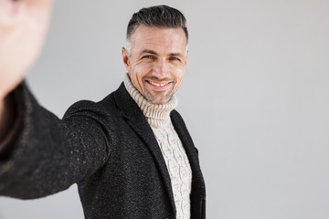 Attractive man wearing coat standing