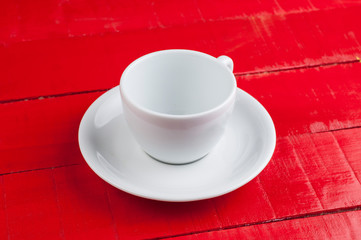 White coffee cup isolated on a red background.