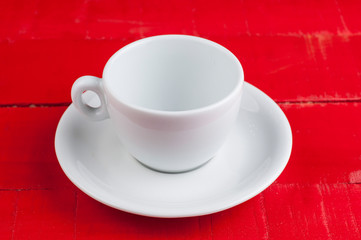 White coffee cup isolated on a red background.