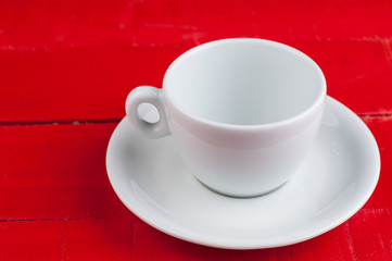 White coffee cup isolated on a red background.