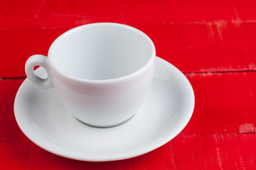 White coffee cup isolated on a red background.