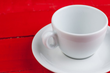 White coffee cup isolated on a red background.