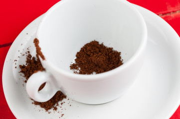 White coffee cup with metal spoon isolated on a red background.