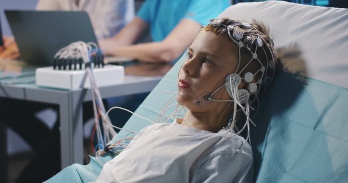 Boy lying in bed during EEG examination