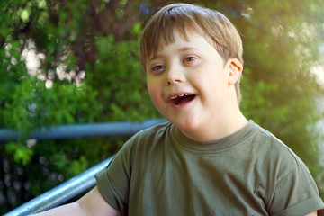 Portrait of a laughing boy with down syndrome while playing in a park