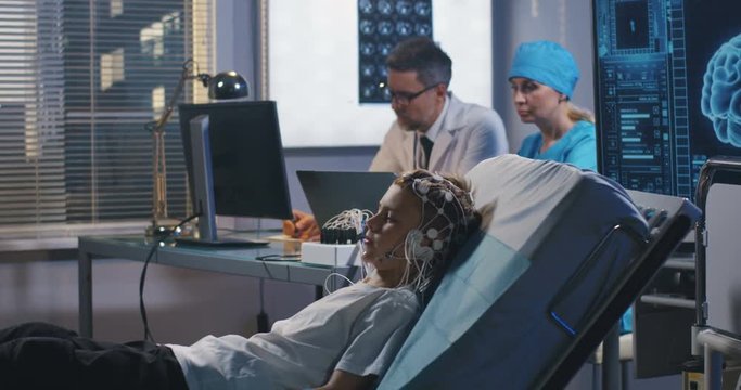 Boy lying in bed during EEG examination