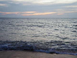 Southern tropical summer evening ocean coast at sunset. Restless sea and waves.