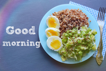 Buckwheat with vegetables. On a wooden background. The view from the top. Copy space. Healthy Breakfast with egg, salad and buckwheat porridge on a dark background. Proper diet. Diet menu.