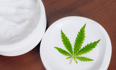 Detail of cannabis hemp cream with marijuana leaf - cannabis topicals concept. Cream from biological and ecological plants of hemp vegetable pharmaceutical oil CBD