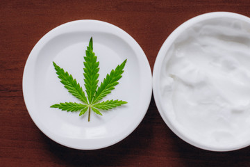 Detail of cannabis hemp cream with marijuana leaf - cannabis topicals concept. Cream from biological and ecological plants of hemp vegetable pharmaceutical oil CBD