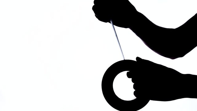 A close-up of Man's hand taking a piece of duct tape roll. Black and white shot, isolated