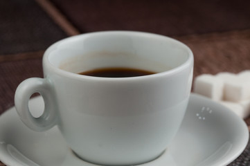 White coffee cup sugar cubes and metal spoon on table.Coffee time