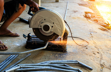 Workers using electric iron cutter.