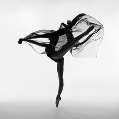 A ballerina dances with a black cloth