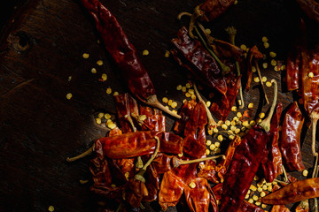 Whole dried chilli peppers with seeds lying in sunlight beam